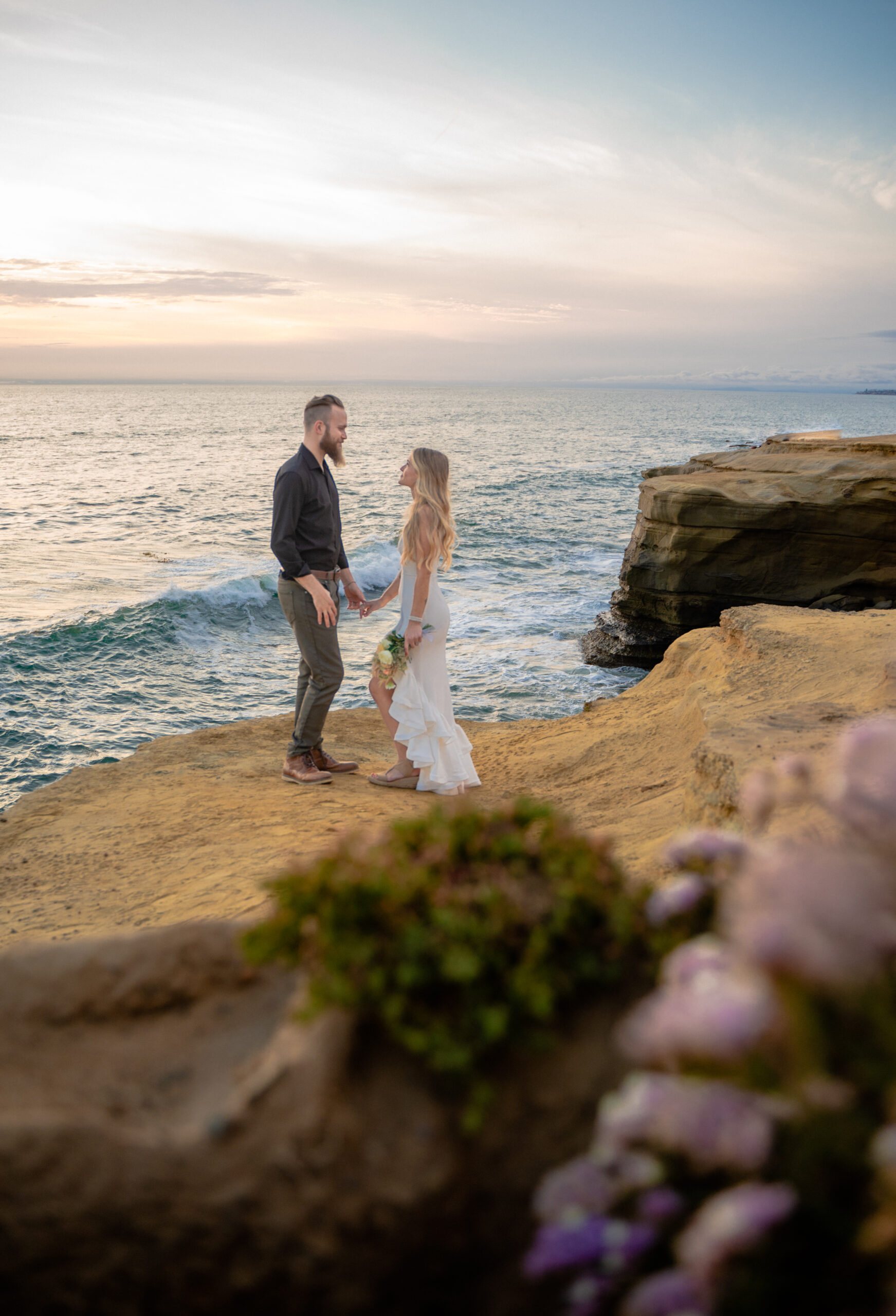 Couple looking at each other on their elopement day at Sunset Cliffs, San Diego.