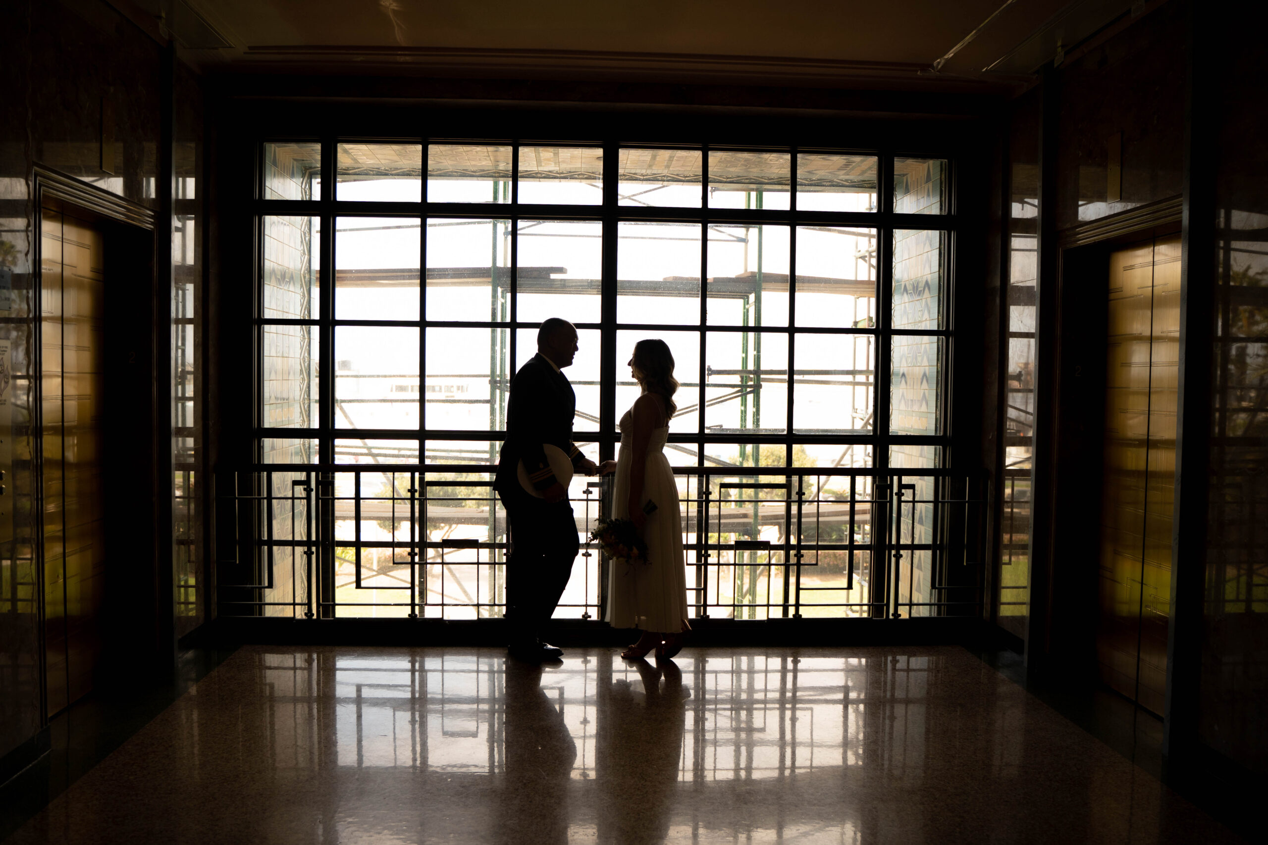 Couple looks at each other at San Diego courthouse wedding building