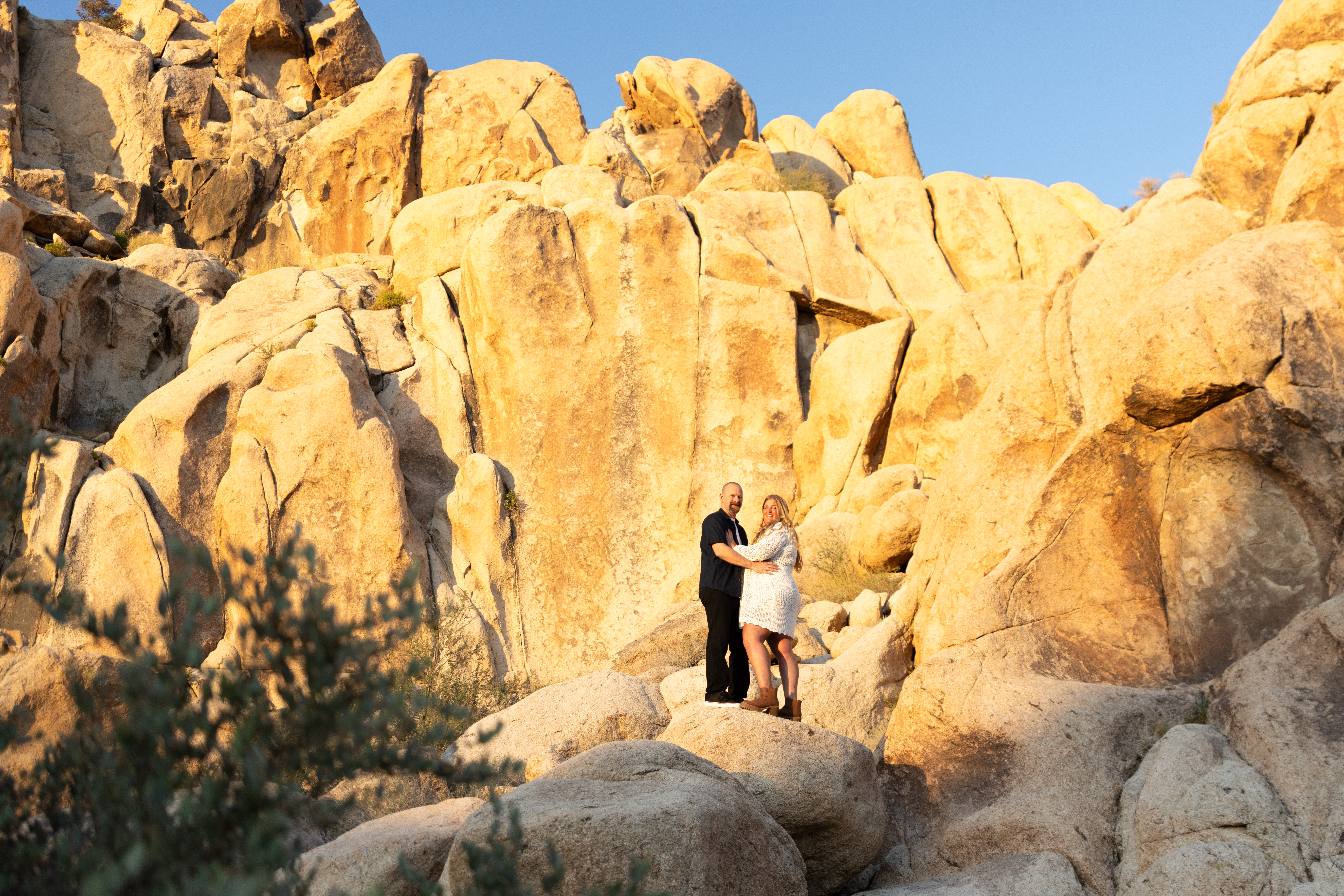 Couple smiling and looking at camera for Joshua Tree engagement session at Indian Cove Amphitheater