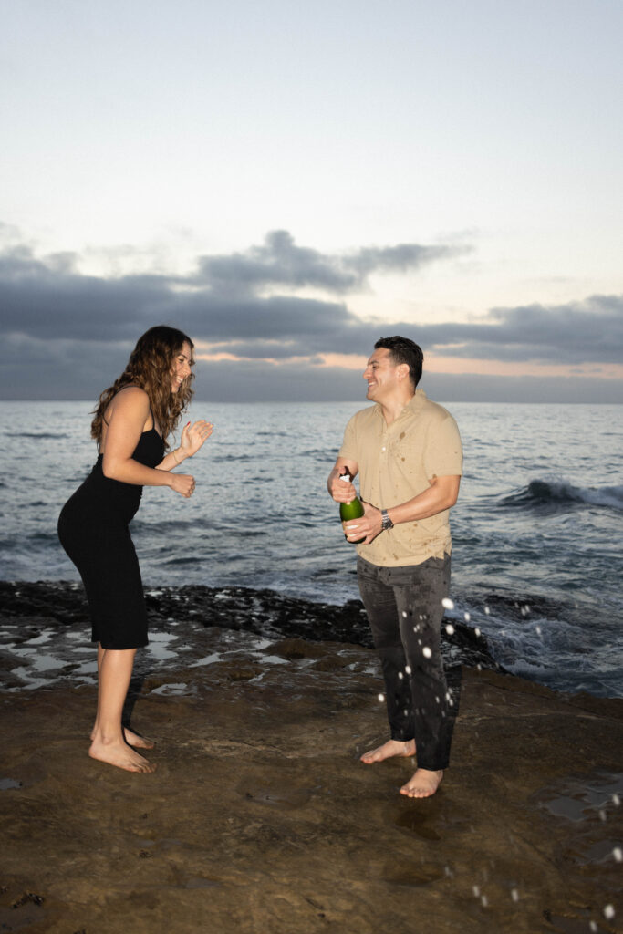 popping champagne to celebrate proposal at Sunset Cliffs