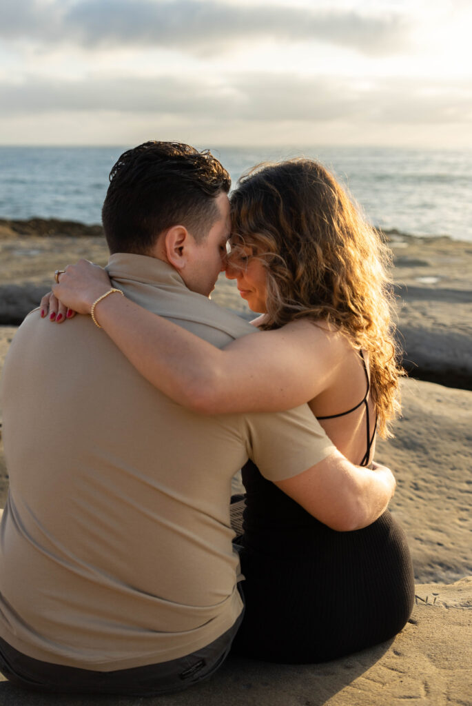 Couple hugging at Sunset Cliffs after proposal