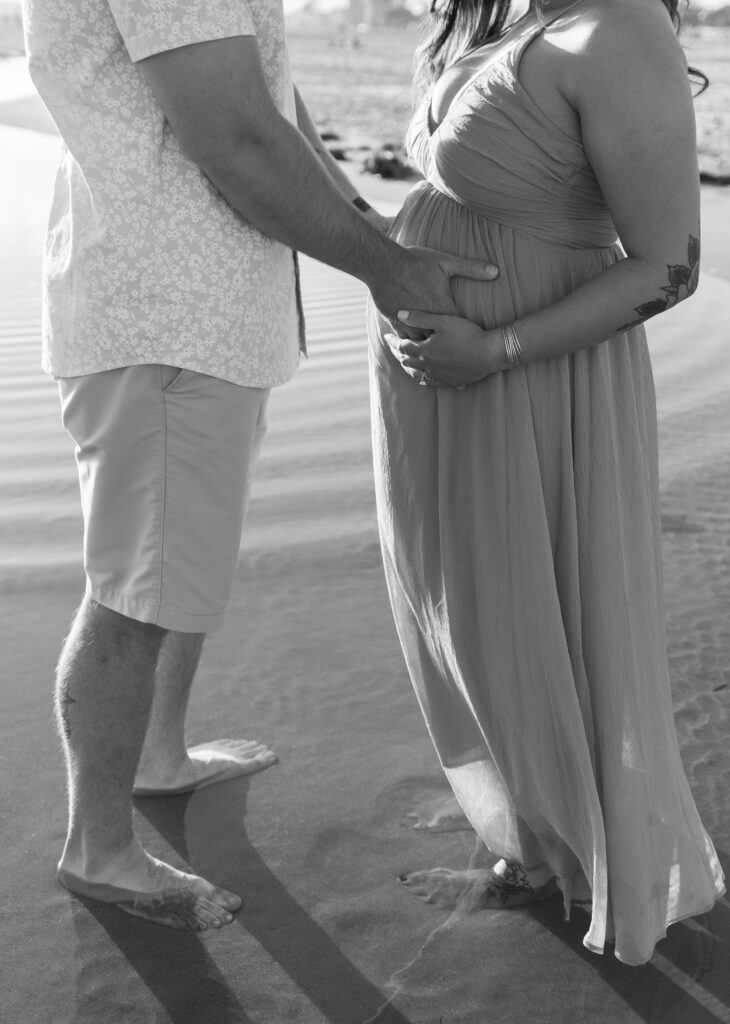 Couple holds onto belly for maternity session at Coronado beach