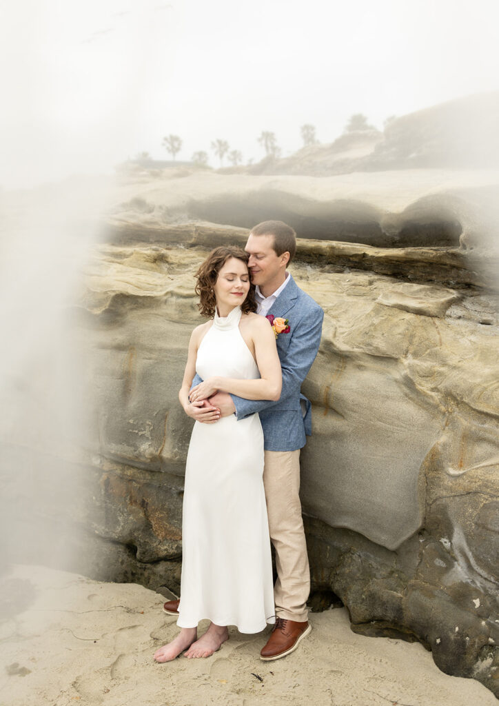 Couple embrace on elopement day at Windansea Beach San Diego