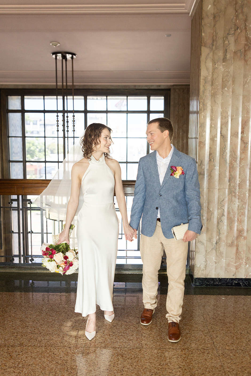 Couple looks at each other while walking at San Diego courthouse marriage office