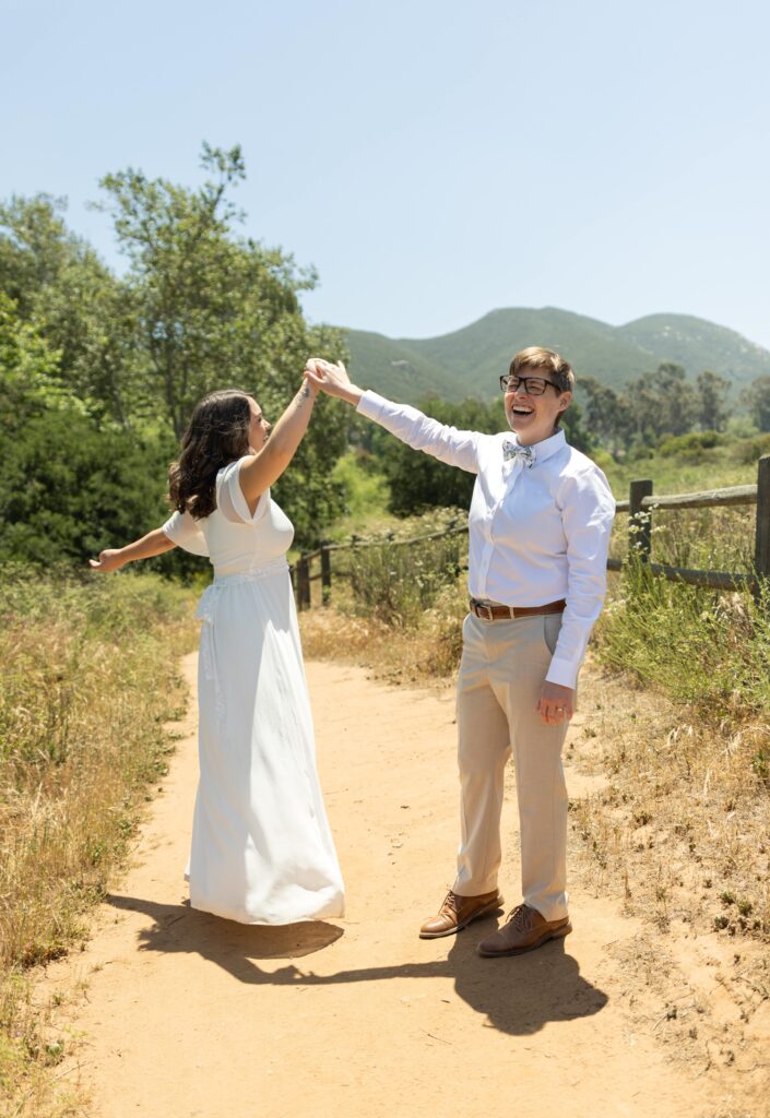 Two brides twirl each other at Mission trails San Diego elopement