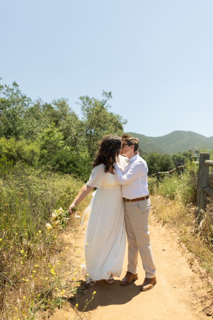 Two brides kiss at Mission Trails San Diego wedding day
